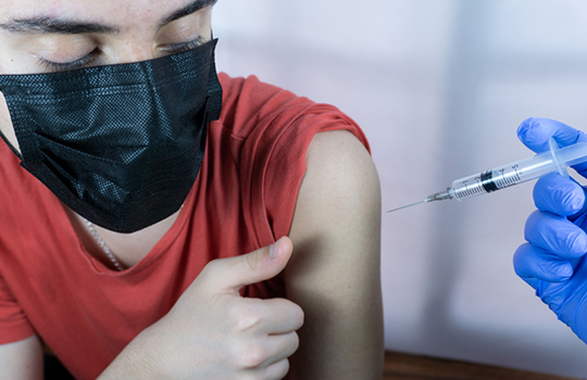 A teenage boy having a vaccine