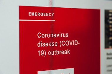 A red sign with white writing highlighting the Covid-19 outbreak.