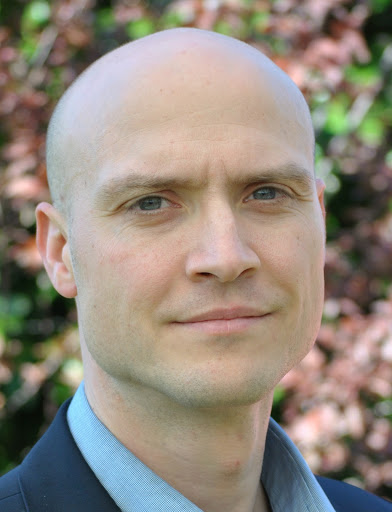Image of blog author Lars G. Hemkens. The image is in colour. Lars is smiling with his mouth shut and has blue eyes. He is wearing a blue shirt and a dark blue blazer.