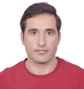 Head and shoulders of Shakir, wearing a red shirt and looking directly at the viewer.