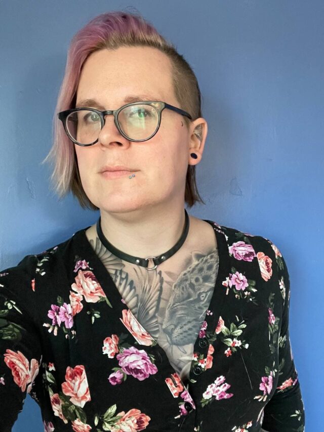 Photo of the author in a black/pink floral top.