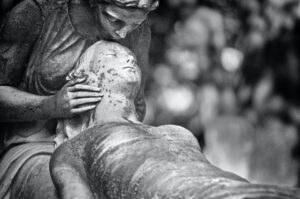 Black and white photograph of statues depicting care during death.