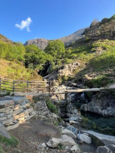 Photo of hiking trail in Norther Wales with a small stream and stone bridge